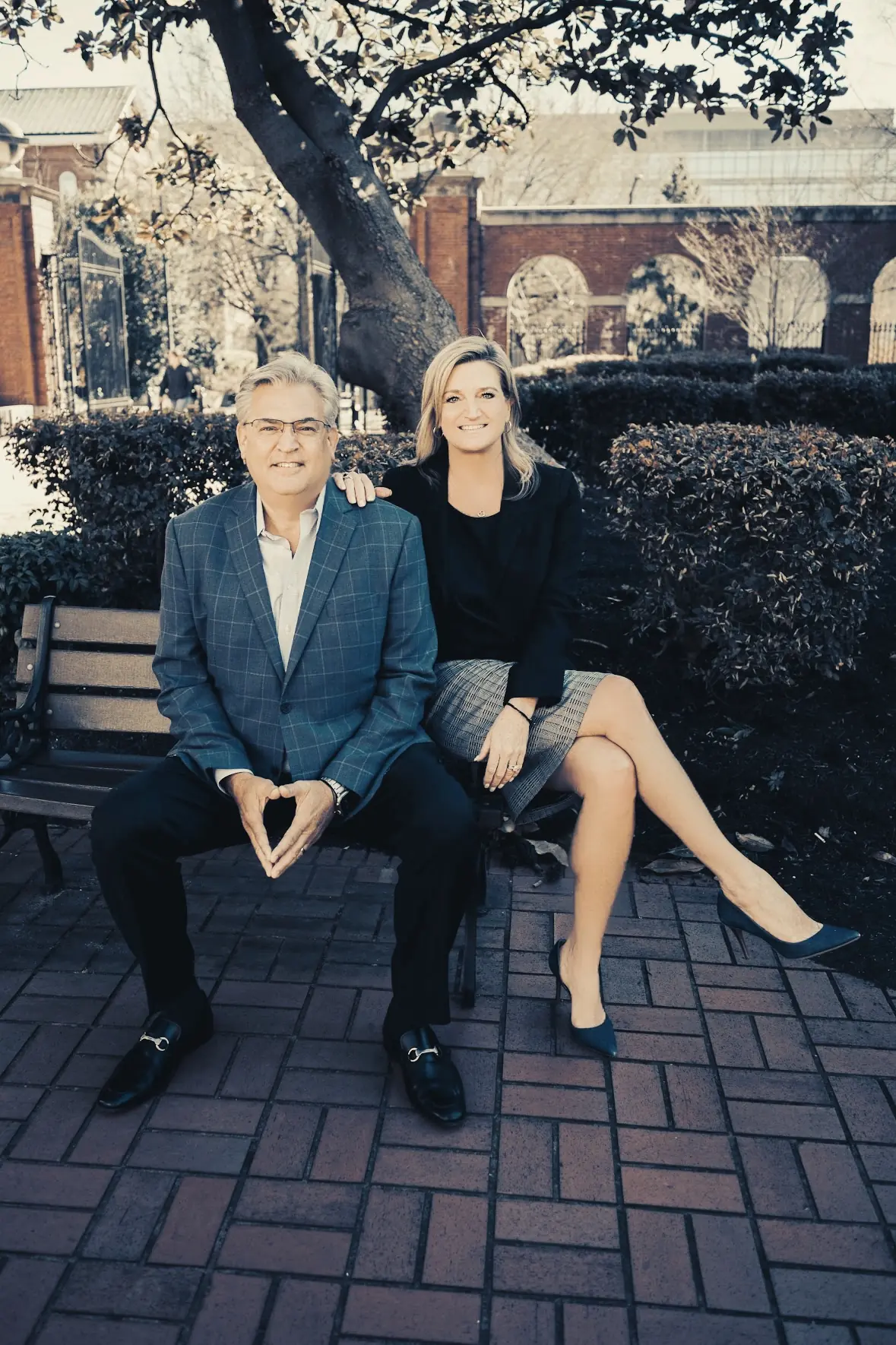 Steve and Melissa Fultz seated on a bench outside an office building