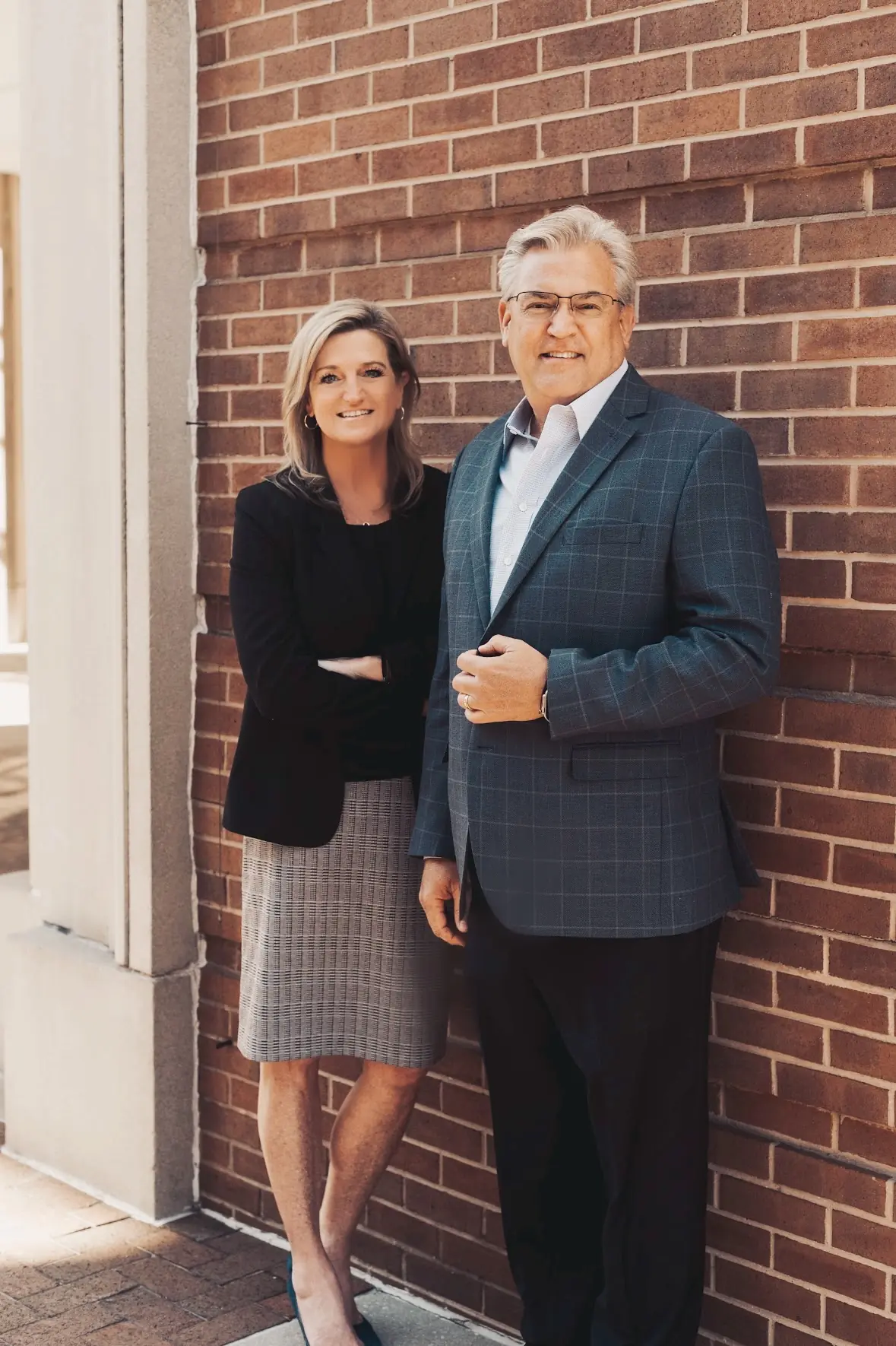 Steve and Melissa Fultz standing against a brick wall